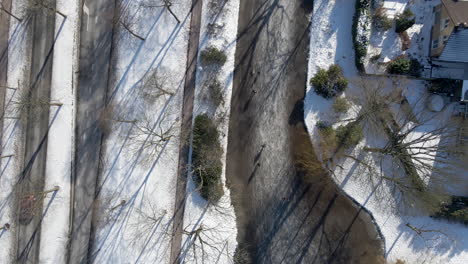 Von-Oben-Nach-Unten-Luftbild-Von-Menschen,-Die-Auf-Einem-Zugefrorenen-Fluss-In-Den-Niederlanden-Skaten