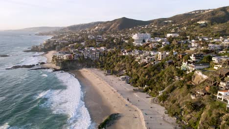 An-aerial-shot-of-Thousand-Steps-Beach,-Laguna---California-showing-coastal-real-estate-and-property-in-the-evening