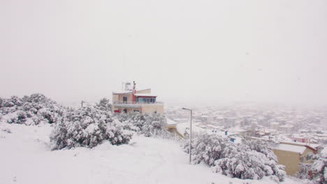 Rare-abnormal-Medea-blanket-snow-storm-across-domestic-Greek-neighbourhood-city-landscape-slow-right-panning