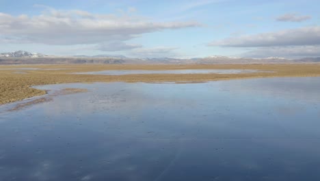 Panoramic-Scenery-Of-Frozen-Water-And-Vast-Flat-Landscape-In-Iceland---aerial-shot