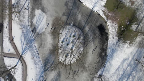 Top-down-aerial-of-people-skating-on-frozen-pond-in-the-Netherlands
