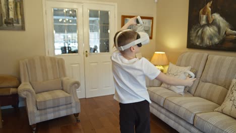 Boy-playing-and-interacting-with-futuristic-virtual-reality-game-and-goggles-at-home