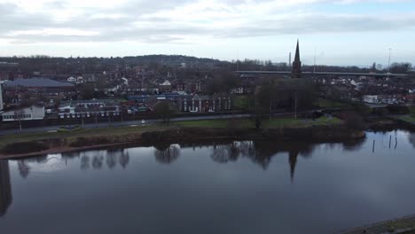 Runcorn-old-town-waterfront-aerial-low-push-in-view-suburban-residential-property-housing-and-church-spire-district
