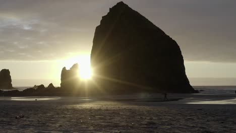 Schöner-Sonnenuntergang-Am-Haystack-Rock,-Cannon-Beach-Oregon,-Person,-Die-Am-Strand-Läuft