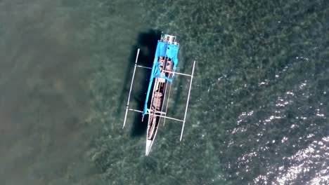 Aerial-view-above-a-boat-at-a-beach,-in-Indonesia---rising,-top-down,-drone-shot