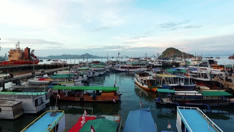 Aerial-view-over-boats,-at-the-Labuan-Bajo-marina,-Flores,-Indonesia---rising,-drone-shot