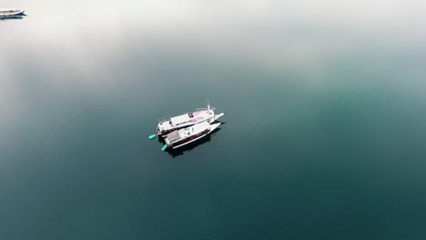 Luftbild-Um-Boote-In-Ruhigem-Wasser,-An-Der-Küste-Des-Komodo-nationalparks,-Labuan-Bajo,-Indonesien---Kreisen,-Drohnenaufnahme