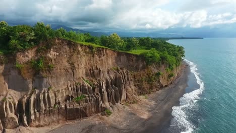 Aerial-view-of-the-steep-coast-of-Samota,-Sumbawa,-in-cloudy,-Indonesia---tracking,-drone-shot