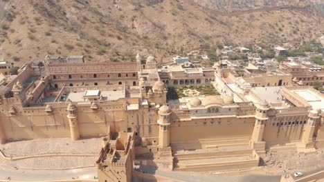 Wide-View-to-the-Amber-fort-Jaleb-chowk-and-Aram-Bagh-surrounded-by-barren-hills-in-Jaipur,-Rajasthan,-India---Aerial-wide-panoramic-orbit-shot