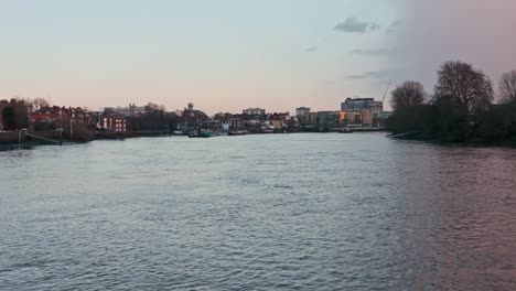 Niedrige-Drohne-Schoss-über-Die-Themse-In-Richtung-Hammersmith-Bridge-Abend