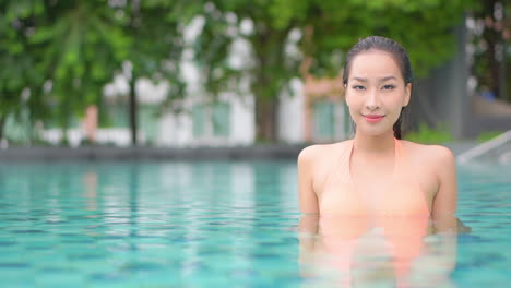 Close-up-of-a-pretty-young-woman-in-a-resort-swimming-pool