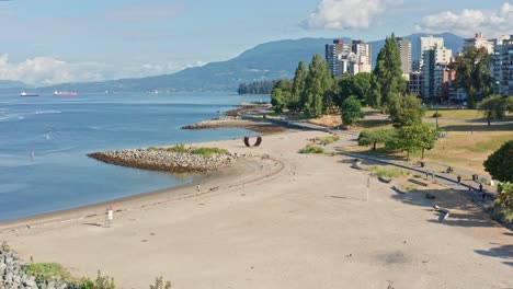 Beautiful-Drone-Aerial-Shot-Flying-Over-Sunset-Beach-Park-Onto-North-Vancouver-British-Columbia,-Canada