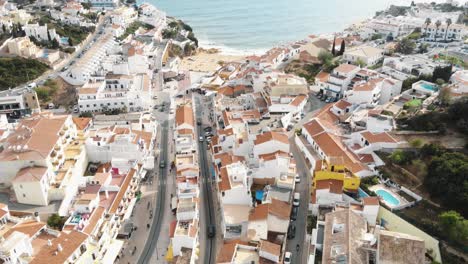 Reveal-of-Atlantic-coast-and-seascape-in-Carvoeiro-Town-in-Algarve,-Portugal---Fly-over-tilt-up-aerial-shot