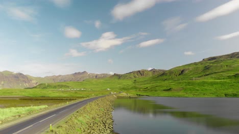 Iceland-Road-To-No-Where,-Accompanied-By-Still-Charm-Lake-Surrounded-By-Green-Scenery