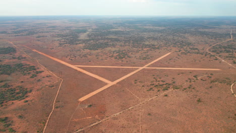 Aerial-view-overlooking-a-airport-and-roads-in-middle-of-endless-desert-and-Australian-outback---tilt-up,-drone-shot