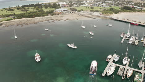 Aerial-view-of-boats,-at-a-dock-on-the-Seal-island,-overcast-day,-in-Australia---Rising,-tilt-shot