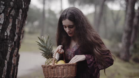 Surprised-shy-spanish-housewife-checking-fruit-basket-gift-in-the-woods