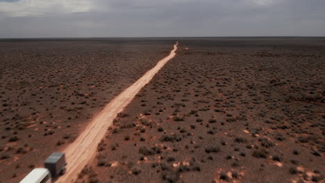 Aerial-drone-view-passing-a-caravan,-driving-on-a-south-Australian-outback