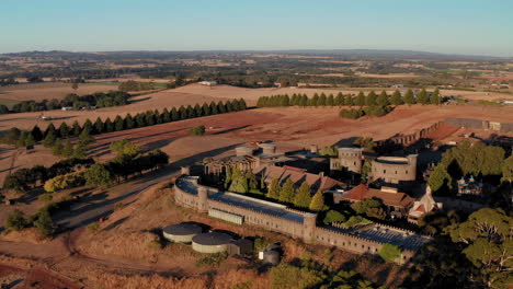 Aerial-view-around-the-Kryal-Castle,-sunset-in-Australia---orbit,-drone-shot