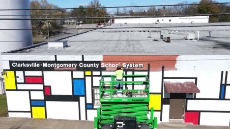 Time-lapse-of-local-artist-painting-a-mural-on-the-side-of-a-school-administration-building