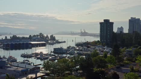 Drone-Aerial-Reveal-Shot-Over-the-Vancouver-Marina,-Moving-Closer-to-the-Cityscape-Skyscrapers-Canada