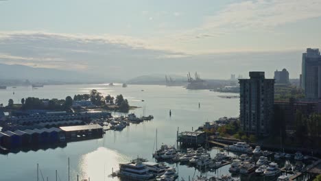 Drone-Aerial-Shot-Over-the-Vancouver-Marina,-Moving-Closer-to-the-Cityscape-Skyscrapers-Canada
