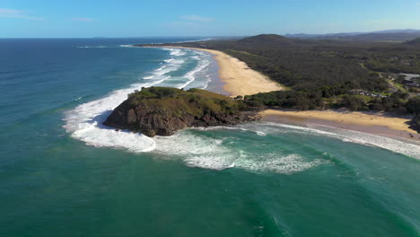 Wide-drone-shot,-rotating-around-coastline-and-rock-outcropping-at-Cabarita-Beach-Australia