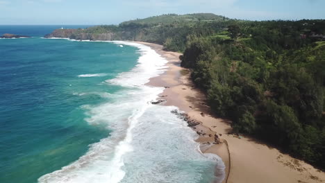 Aerial-drone-of-Kilauea-Lighthouse-by-coastline-waves-on-Kauai,-Hawaii