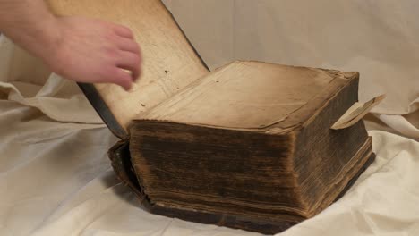 Close-slomo-slide-shot-of-male-hand-opening-worn-old-heavy-bible