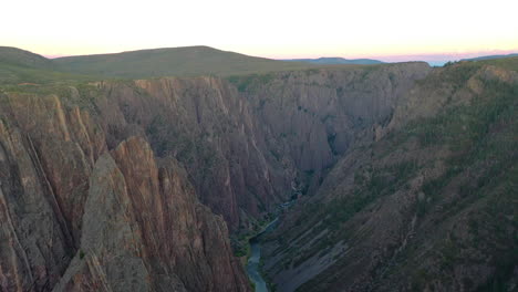 Aerial-Drone-Footage,-the-Black-Canyon-of-the-Gunnison-National-Park-in-Montrose-Colorado-with-the-River-Flowing-at-the-Bottom-of-the-Rocky-Mountains