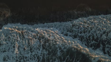 Top-view-of-ocean-waves-during-sunset