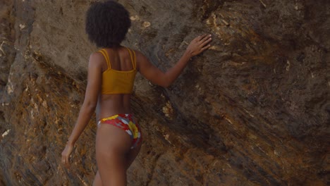 Exotic-black-princess-walks-along-the-rocks-in-a-sexy-yellow-bikini