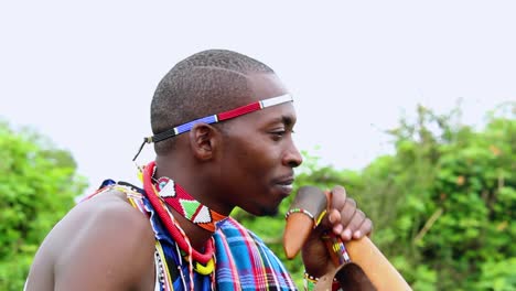 Persona-Masai-Bebiendo-Leche-Y-Saludando-Con-La-Mano,-Vistiendo-Ropa-Cultural,-En-Kenia