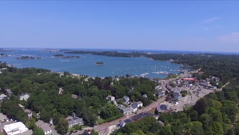 Aerial-view-of-Harborside-Town-Hingham-in-a-sea-bay-with-a-harbor-on-a-beautiful-sunny-day-and-a-blue-sky,-tilt-down-shot,-travel-concept