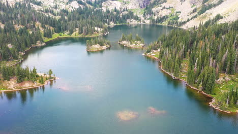 Aerial-Drone-Footage-of-a-Beautiful-Clear-Blue-Lake-Water-in-Nederland-Colorado-Surrounded-by-a-Thick-Pine-Tree-Forest-during-Summer-in-the-Rocky-Mountains