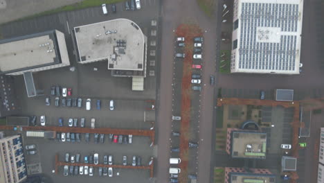 Top-down-aerial-of-car-driving-over-busy-industrial-terrain