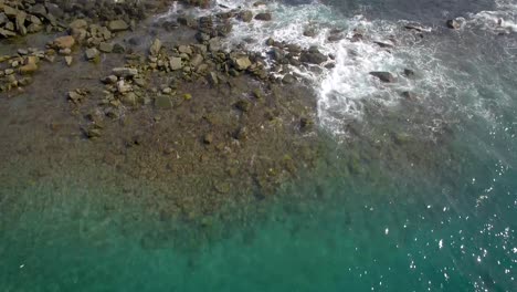 Bird-eye-view-of-a-blue-Caribbean-Sea-and-waves-hitting-against-a-breakwater