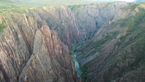 Aerial-Drone-Footage-Reveal-Shot-of-the-Black-Canyon-of-the-Gunnison-National-Park-in-Montrose-Colorado-with-the-River-Flowing-at-the-Bottom-of-the-Rocky-Mountains
