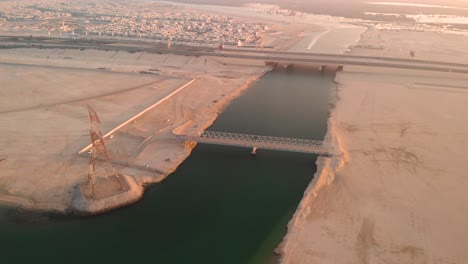 Aerial-panning-shot-over-Abu-Dhabi-metal-bridge-across-waterway