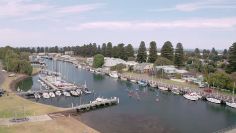 Beautiful-aerial-dolly-shot-of-Stand-up-Board-paddling-in-marina-harbor-of-Port-Fairy-during-sunny-day
