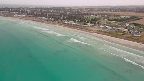 Aerial-view-of-exotic-australian-ocean,-empty-sandy-beach-and-nature-landscape-in-background