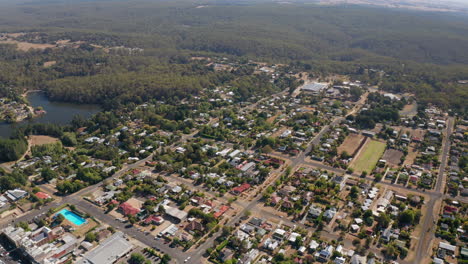 Cinematic-aerial-shot-of-Daylesford-City,-the-natural-lake-and-the-famous-Great-Dividing-Range-in-background