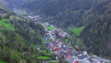 Drone-view-of-a-town-in-the-mountain-valley-at-Eisenkappel-Vellach,-Austria