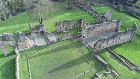 Basingwerk-abbey-landmark-medieval-abandoned-Welsh-ruins-Aerial-view-tilt-up-descent