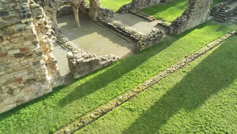 Basingwerk-abbey-landmark-medieval-abandoned-Welsh-ruins-Aerial-view-birdseye-lowering-tilt-up