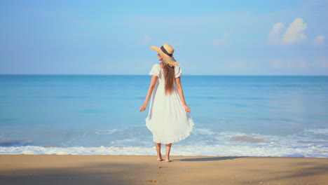 Back-view-of-woman-dressed-in-white-on-seashore