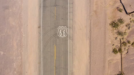 Top-down-view-of-route-66-as-car-passes-highway-marker
