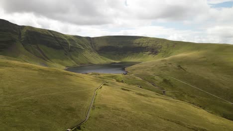 Llyn-y-Fan-Fach-beautiful-Brecon-beacons-mountain-lake-scenic-valley-countryside-aerial-view-landscape-slow-push-in