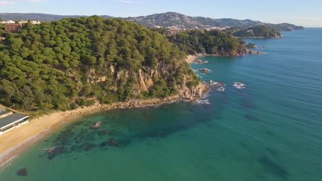 Luftbild-Mit-Drohne-Von-Lloret-De-Mar-Unberührter-Strand-Mit-Grüner-Vegetation-Im-Mittelmeer-Europa-Barcelona