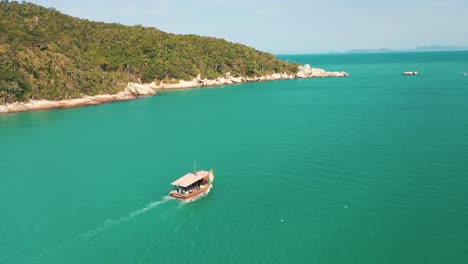 Tourism-boat-on-turquoise-water-color-and-paradisiac-rainforest-scenery-sea-aerial-view